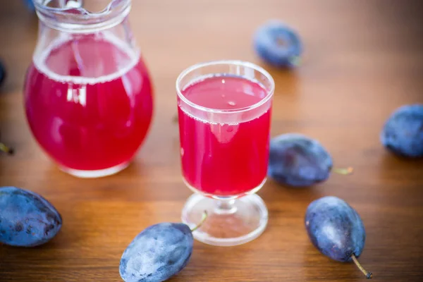 Compote van herfst blauwe pruimen op een houten tafel. — Stockfoto