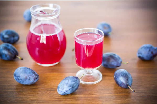 Compote van herfst blauwe pruimen op een houten tafel. — Stockfoto