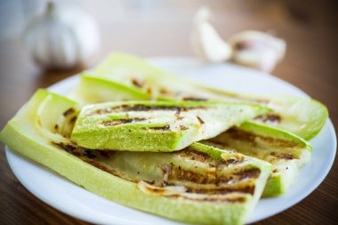 bir tabakta soğan ile ızgara kabak, bir masaüzerinde.