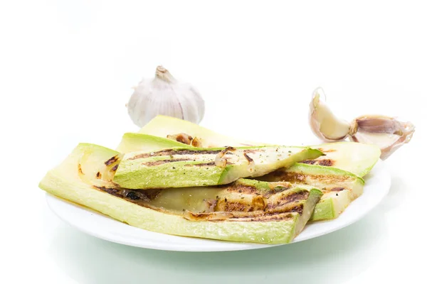Grilled zucchini with onions in a plate, isolated on white — Stock Photo, Image