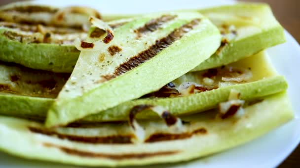 Grilled zucchini with onions in a plate, on a table. — Stock Video