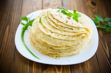 bir tabakta çok kızarmış ince krep, bir masada.