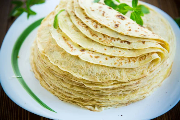 bir tabakta çok kızarmış ince krep, bir masada.