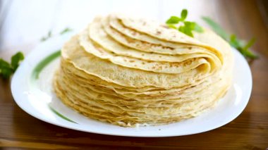 bir tabakta çok kızarmış ince krep, bir masada.