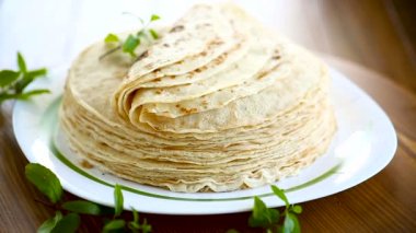 bir tabakta çok kızarmış ince krep, bir masada.