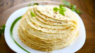 bir tabakta çok kızarmış ince krep, bir masada.