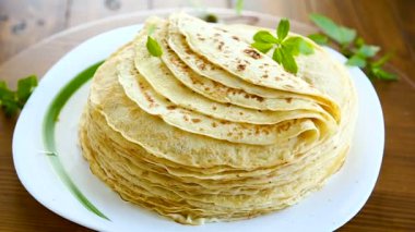 bir tabakta çok kızarmış ince krep, bir masada.