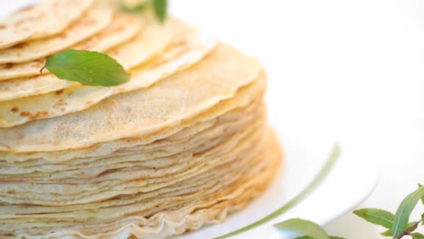Many fried thin pancakes in a plate, on white background. — Stock Video