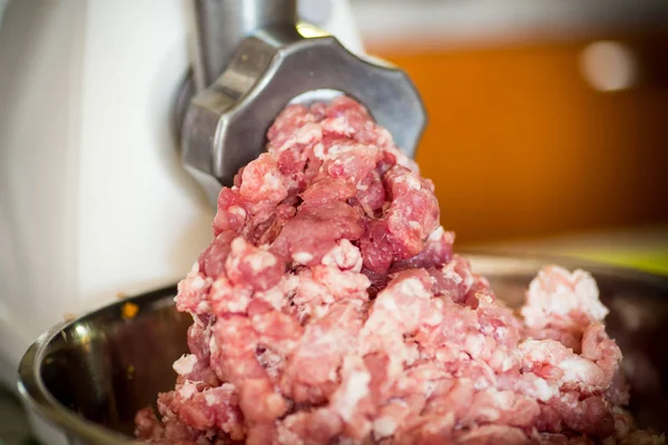 An electric meat grinder twists the meat — Stock Photo, Image