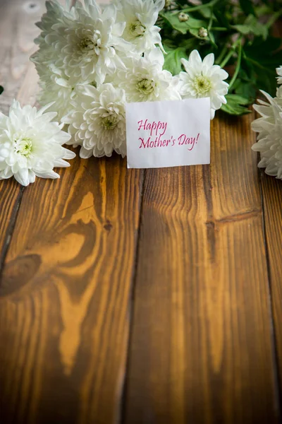 Bukiet białych chryzantemy na drewnianym stole — Zdjęcie stockowe
