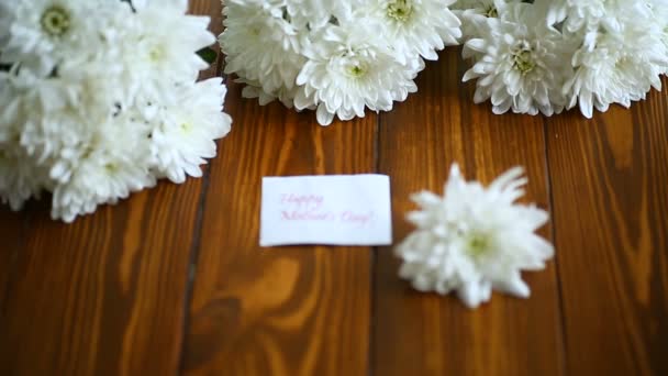 Букет белых хризантем на деревянном столе — стоковое видео