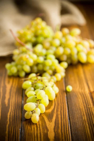 Monte de uvas verdes em uma mesa de madeira escura — Fotografia de Stock