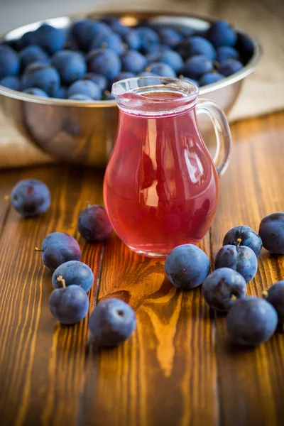 Sweet kompott av höst blå plommon i ett glas dekanter — Stockfoto