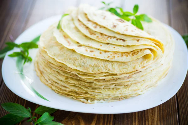 Many fried thin pancakes in a plate, on a table. — Stock Photo, Image