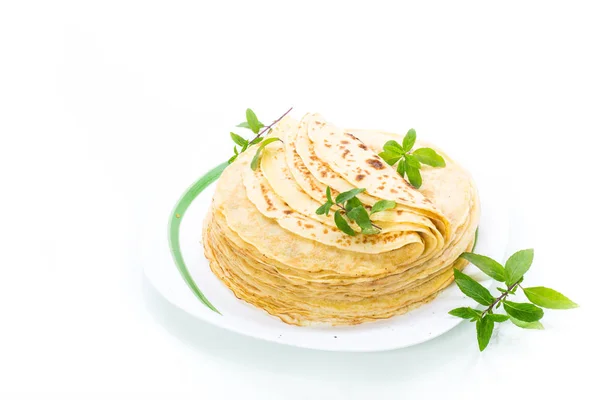 De nombreuses crêpes fines frites dans une assiette, sur fond blanc . — Photo