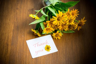 bir ahşap üzerinde sarı büyük papatyalar buketi