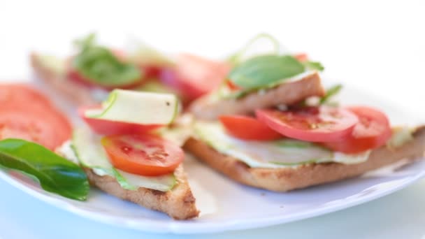 Sabroso sándwich con pasta de cuajada, pepinos frescos y tomates — Vídeo de stock