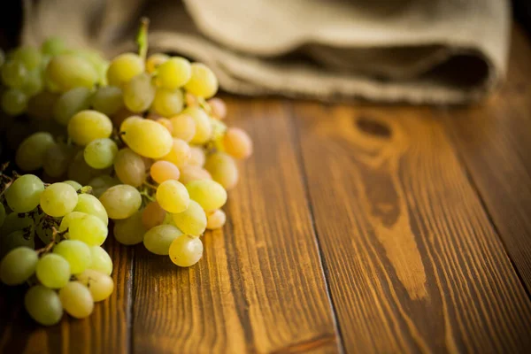 Racimo de uvas verdes sobre una mesa de madera oscura — Foto de Stock