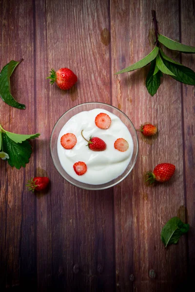 Süßer hausgemachter Joghurt mit roten reifen frischen Erdbeeren lizenzfreie Stockfotos