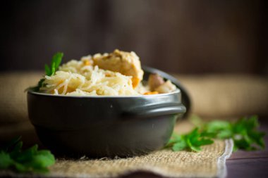 Sebzeli pilav ve ahşap bir masada seramik kasede et.