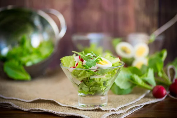 Spring salad with arugula, boiled eggs, fresh radish, salad leaves in a glass bowl — Stock Photo, Image