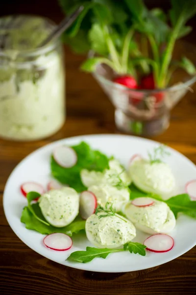 Boiled stuffed eggs with green cheese filling with arugula leaves and radish — Stock Photo, Image