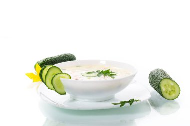 Beyaz arka planda sebzeli salatalık çorbası.