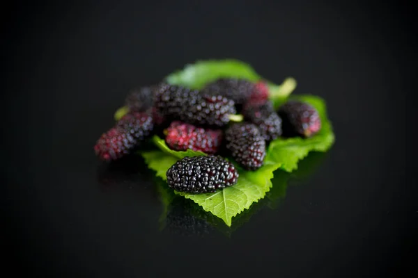 Mulberry berry with leaf on black background — Stock Photo, Image