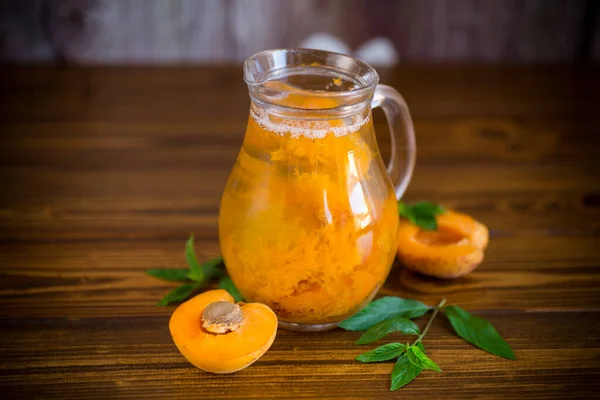 Cold apricot compote in a glass decanter — Stock Photo, Image