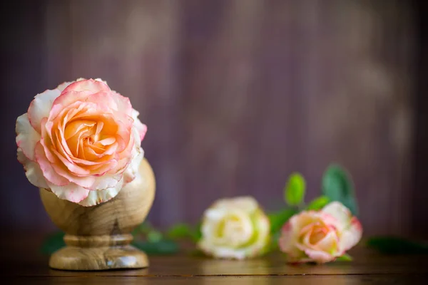 Liten bukett vackra rosa rosor på ett träbord — Stockfoto