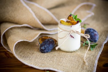 Bardakta olgun erik dilimleriyle ev yapımı tatlı yoğurt.