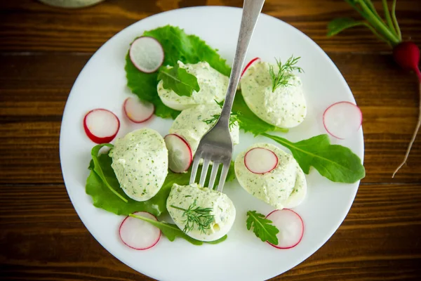 Boiled stuffed eggs with green cheese filling with arugula leaves and radish — Stock Photo, Image