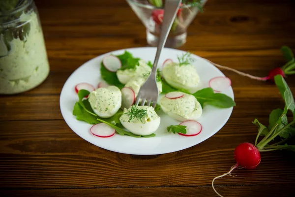 Ovos recheados cozidos com queijo verde recheio com folhas de arugula e rabanete — Fotografia de Stock