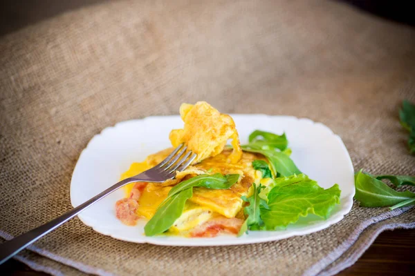 Жареный омлет с овощами и рукколой в тарелке — стоковое фото