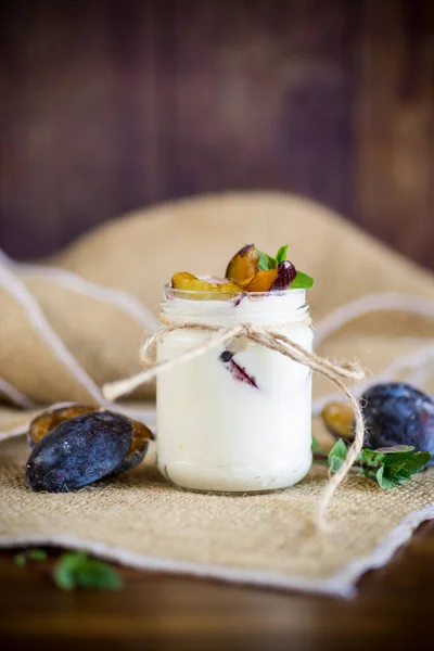 Homemade sweet yogurt with slices of ripe plums in a glass — Stock Photo, Image