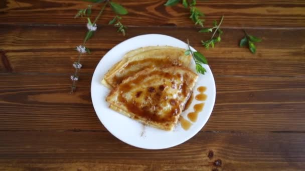 Tortitas finas fritas con caramelo dulce en un plato — Vídeo de stock