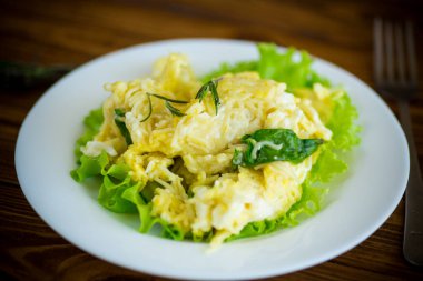 İnce vermicelli omlet ve ahşap bir masada salata yaprakları.