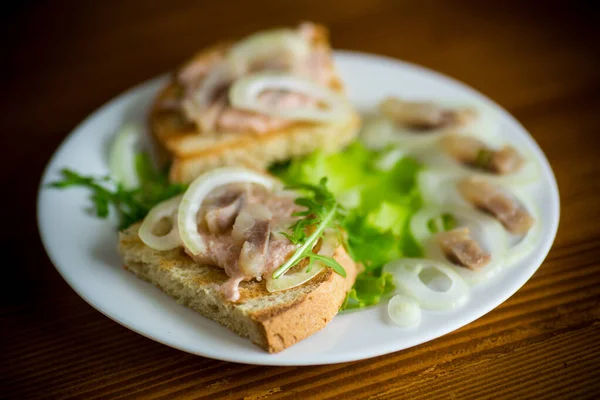 Broodje Met Salade Haring Kruiden Met Uien Een Bord Tafel — Stockfoto