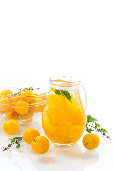 用成熟的黄樱桃李子在白盘上的玻璃瓶里煮出甜甜的椰子酱 — 图库照片