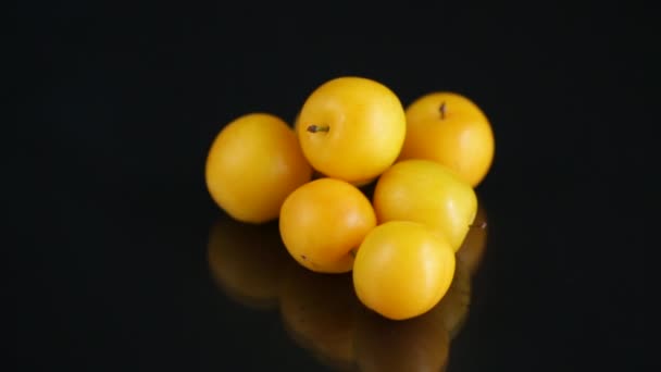 Gelbe Kirschpflaumen auf schwarzem Hintergrund — Stockvideo