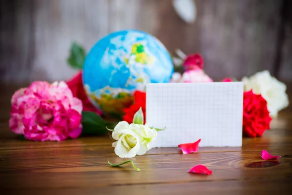 Globe with books and flowers on table — Stock Photo, Image