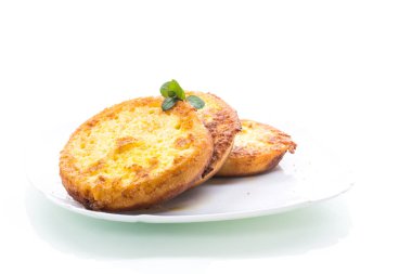 Tabakta hamurda kızartılmış yuvarlak ekmek parçaları.