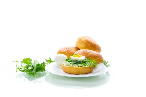 Homemade bun with cheese spread, fresh arugula and boiled egg in a plate — Stock Photo, Image