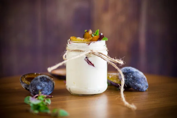 Homemade sweet yogurt with slices of ripe plums in a glass — Stock Photo, Image