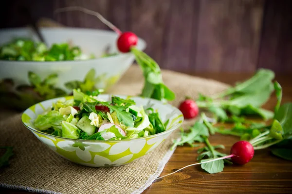 早熟蔬菜 莴苣叶 萝卜和香草制成的春色拉放在木制桌子上的盘子里 — 图库照片
