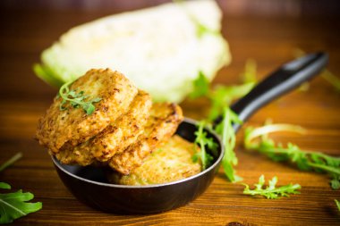 Sebzeli vejetaryen kızarmış lahana krepleri ahşap bir masada tavada.