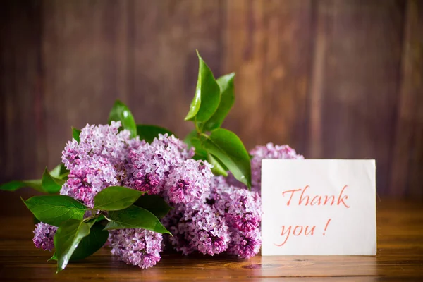 一束美丽的春天紫丁香花在一张木制桌子上 — 图库照片