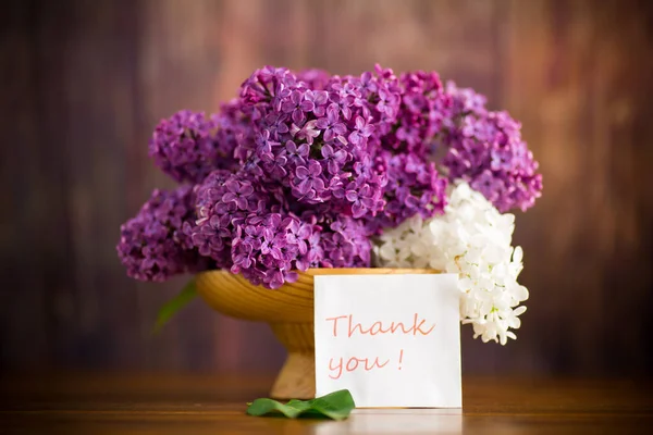 木製のテーブルの上の木製の花瓶に美しい紫色のライラックの花束 — ストック写真