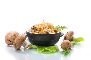 Beyaz arka planda izole edilmiş seramik kasede mantarlı vejetaryen pilavı.