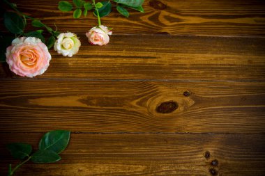 Tahta bir masanın üzerinde güzel pembe güllerden oluşan küçük bir buket